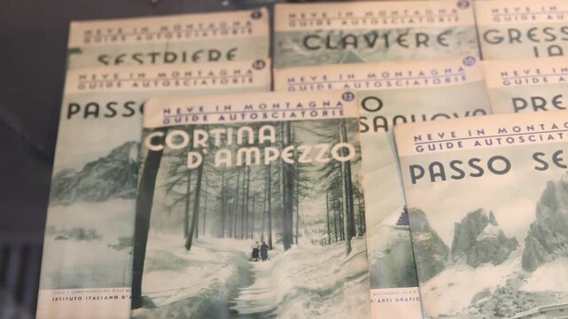 Detailed view of historic vintage paper guides and memorabilia from the 1956 Winter Olympics held in Cortina d'Ampezzo, Italy