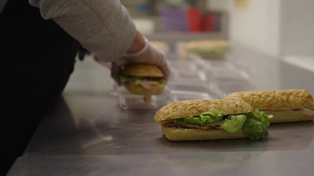 4k Slow motion of preparing and packaging delicious sandwiches in a commissary setting.