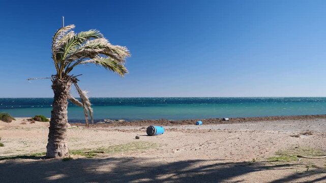 Strong winds on a beach. Overturned trash cans and clouds of sand. Slow motion x0.5