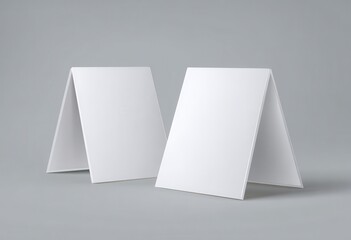 Naklejka premium Two blank white aframe table tents or standing signs mockup template on a neutral gray background