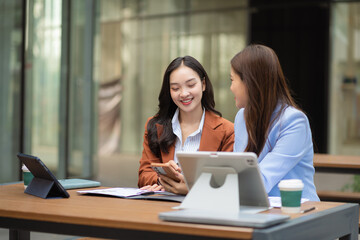 Obraz premium Team of businesswomen analyzing financial charts, planning company growth, and managing corporate strategy