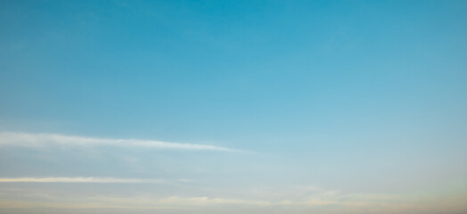 the sky is clear blue with fluffy white clouds, the sky is very bright, and the sun shines.