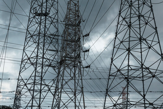 曇り空を背景に見る高圧送電線の鉄塔