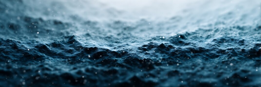 Close-up of dark blue ocean waves with water droplets splashing, highlighting the texture and motion under a cloudy sky.