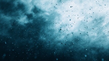 Obraz premium Raindrops falling against a dark, cloudy sky creating a moody and atmospheric scene.