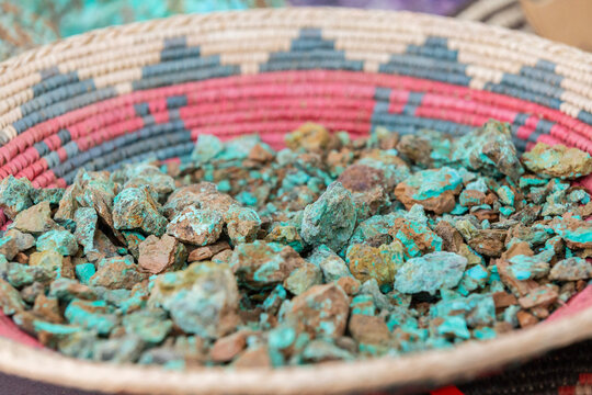 Blue raw turquoise stones on a traditional Native American woven bowl plate