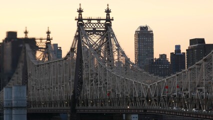 Fototapeta premium New York City Manhattan Midtown skyline from Queens, Queensboro bridge architecture, United States. Cityscape from rooftop in Long Island, Hunters Point. Urban sunset over transport metallic bridge.