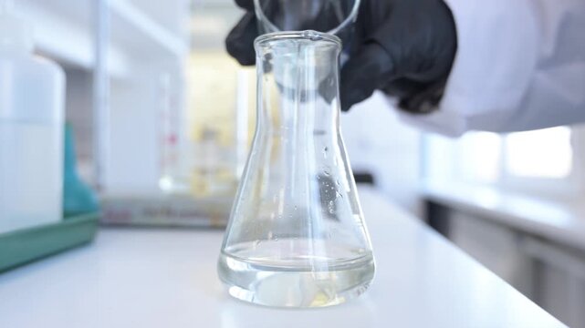 Close-up of hand holding test tube with chemical reagents in laboratory. Scientific research, chemistry education, and lab work concept.
