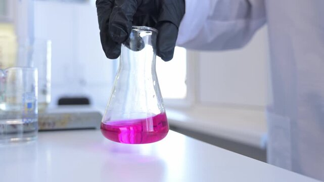 Close-up of hand holding test tube with chemical reagents in laboratory. Scientific research, chemistry education, and lab work concept.