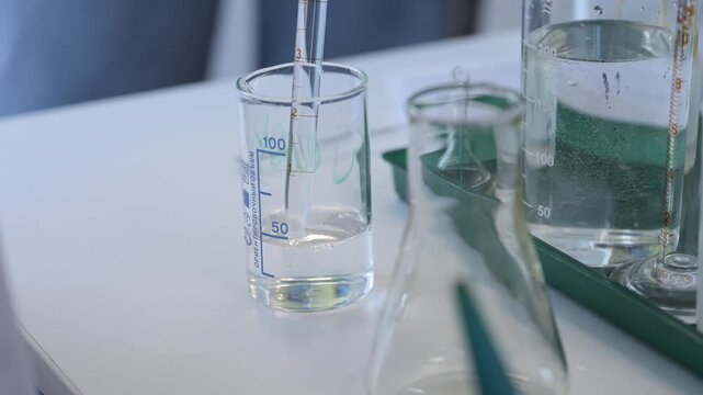 Close-up of hand holding test tube with chemical reagents in laboratory. Scientific research, chemistry education, and lab work concept.