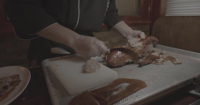 Roasted Peking duck dish being prepared for serving to guests
