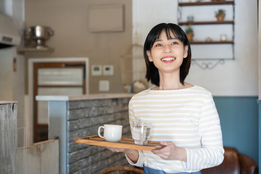 お店でコーヒーを持って笑っている女性
