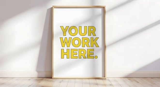 A blank canvas with the words your work here in a modern frame on a wooden floor.