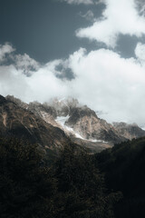 Alpine glacier covered by clouds in a dramatic mountain lanscape