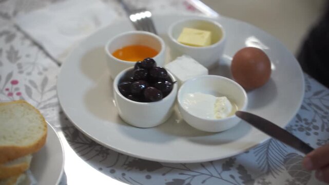 Breakfast of workers at the factory in close-up. There are eggs, cheese, butter, honey, prunes, tea and bread on the table.