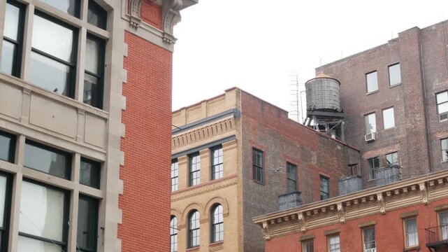New York City urban red brick building architecture, Lower Manhattan rooftop, United States of America. Water tower on roof. Classic water tanks in Downtown. Varick street in Tribeca. Fire station