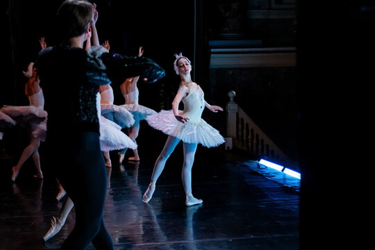 Woman ballet dancer in white tutu performing on stage