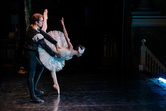 classical ballet dancer in tutu performing on stage with partner.