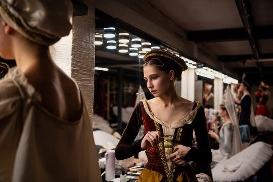 ballerina in costume opening water bottle in dressing room