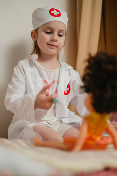 Little girl playing doctor caring for her toys at home