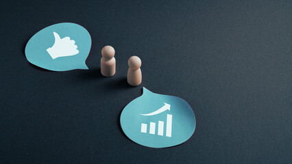 Constructive feedback concept with wooden figures and speech bubbles showing approval and business...