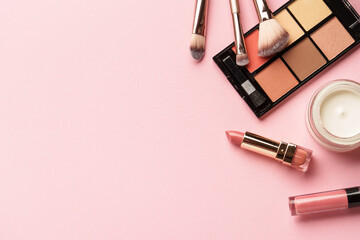 Makeup products flat lay background on pink.