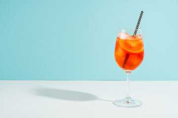 Aperol Spritz, traditional summer cocktail at blue background.