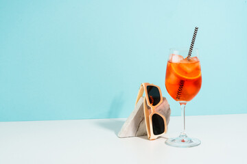 Aperol Spritz, traditional summer cocktail at blue background.