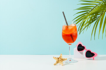 Aperol Spritz, traditional summer cocktail at blue background.