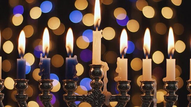 Lit candles in a candelabrum creating a warm and festive glow against a bokeh