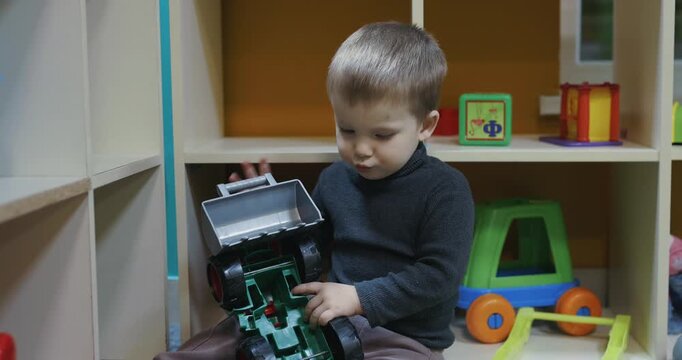 A boy plays with excavator at the kids club