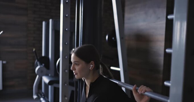 Smith machine squats, woman at the gym, slow motion