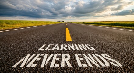Rural asphalt road with painted learning message, sunset farm landscape, lifelong learning Concept