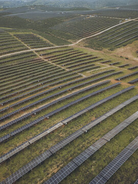 Aerial view of rows and rows of solar panels stretch across the landscape, capturing the sun's rays in a symphony of light and shadow, Lagos, Faro District, Portugal.
