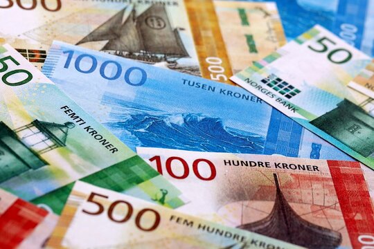 Norwegian krone money bills pile on table. Norway banknotes of NOK currency close up.