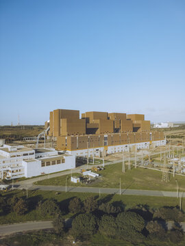 Aerial view of the industrial hydrogen energy complex casting shadows under a clear sky, with a blend of modern architecture and open spaces, Sines, Setubal, Portugal.