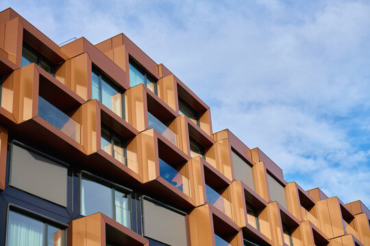 Contemporary building exterior with large glass windows and angular geometric frames. Concept of modern architecture, residential design and urban development.