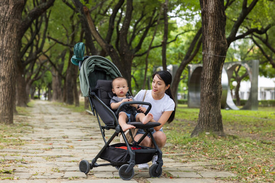 Mother and baby in park with stroller outdoors