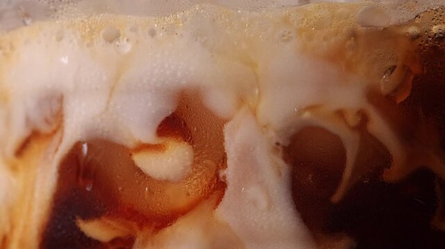 4K Macro close-up of fresh milk pouring into black coffee, creating smooth creamy swirls and rich brown patterns, Abstract liquid texture with dynamic motion perfect for beverage and refreshment conce