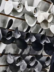 Different types of boat propellers displayed on a wall for sale in a shop specializing in marine...