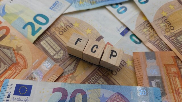 FCP acronym made of wooden letter cubes on pile of Euro banknotes. Fonds Commun de Placement (Mutual Investment Fund)
