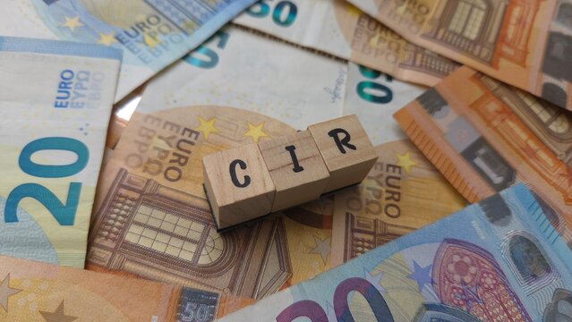 CIR acronym made of wooden letter cubes on pile of Euro banknotes. Cr&eacute;dit d'Imp&ocirc;t Recherche (Research Tax Credit)