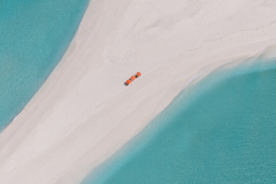 Aerial view of a bright orange object contrasting against the white sandbar embraced by the turquoise sea, Vashafaru, Haa Alif Atoll, Maldives.