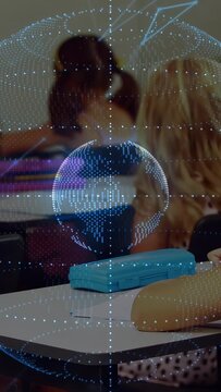 Vertical video: Desk focus starting rotating dot globe over desks two girls watching for school