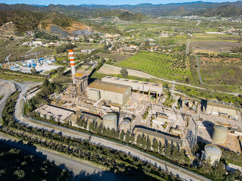 Aerial view of the industrial complex standing in contrast with the lush greenery, a testament to human endeavor against the natural landscape, Malaga, Andalusia, Spain.