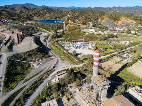 Aerial view of the stark industrial landscape meets the rugged mountains, a contrast of human intervention and natural beauty., Malaga, Andalusia, Spain.