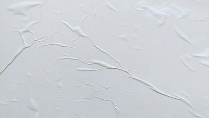 Obraz premium Blank abstract background of white crumpled paper. Creased poster texture with wavy surface. Wrinkled white paper background detail.