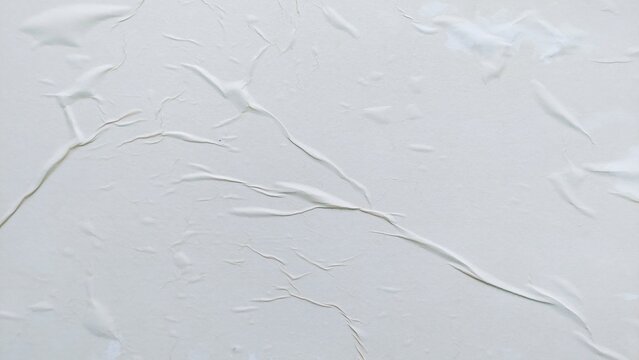 Blank abstract background of white crumpled paper. Creased poster texture with wavy surface. Wrinkled white paper background detail.