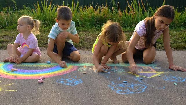 Children drawing with chalk on the asphalt. Selective focus. Kid.