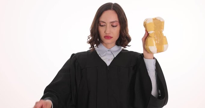 Woman judge holds handcuffs and evidence drug package on white background. Magistrate raises cuffs presenting seized bundle for legal case file